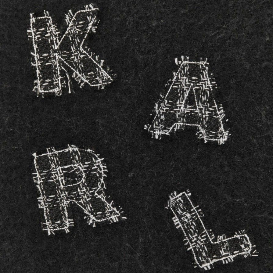 Close-up of Karl Lagerfeld scarf showing embroidered 'KARL' letters on dark wool fabric