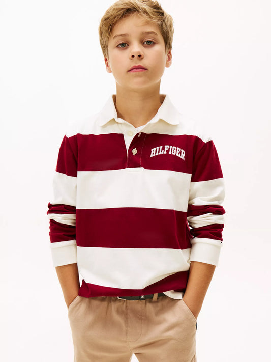 Child wearing a red and white striped polo shirt with 'Tommy Hilfiger' branding