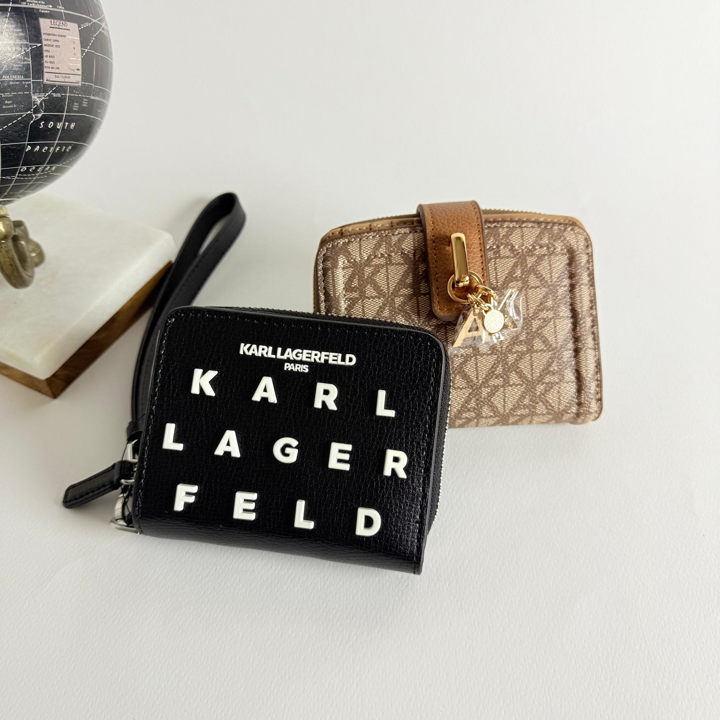 Two Karl Lagerfeld wallets, one black and one beige with gold accents