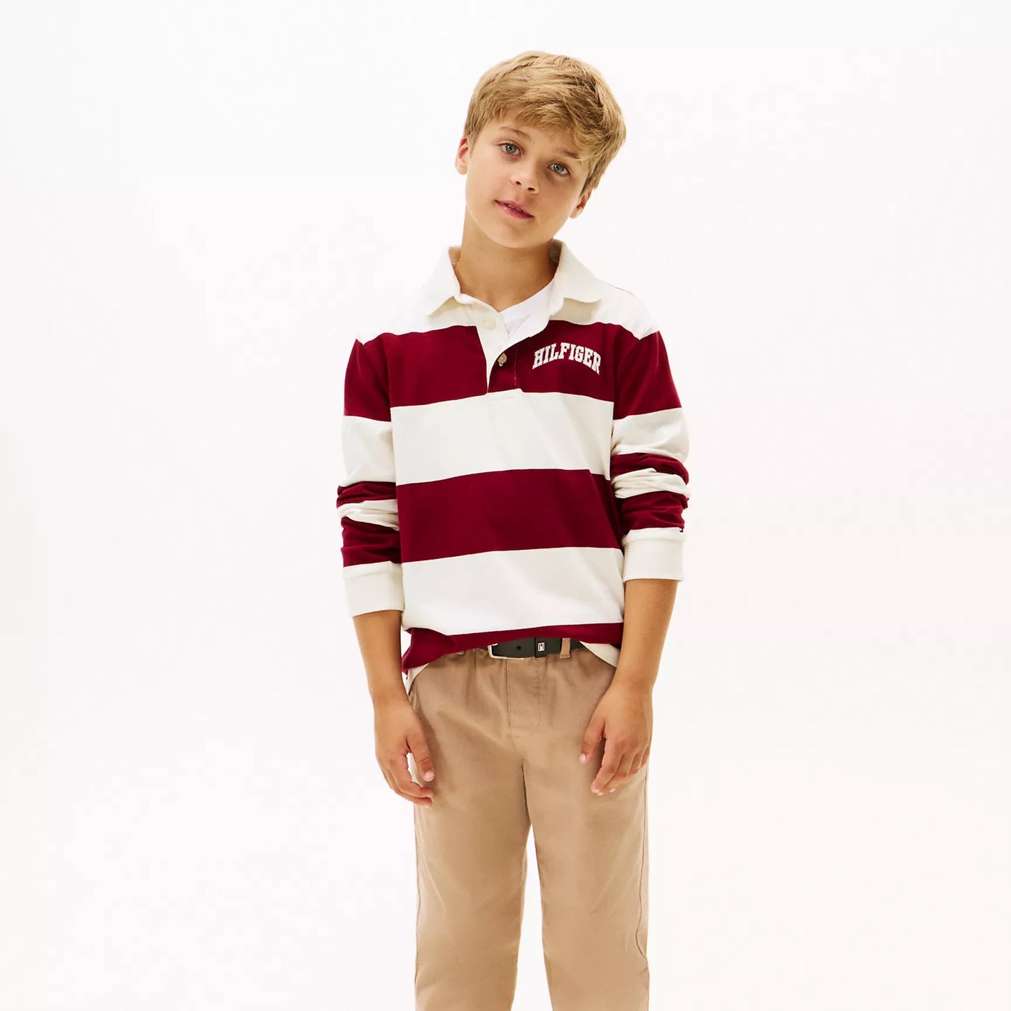 Young boy wearing a striped rugby shirt in burgundy and white